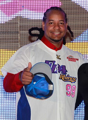Former MLB star Manny Ramirez poses for media with wearing his new jersey after signing a short-term contract to play on the EDA Rhinos in Taiwan's professional baseball league in Kaohsiung, Taiwan, Tuesday, March 12, 2013. The EDA Rhinos say Ramirez will earn $25,000 a month to appear with the team during this year's March-November season. (AP Photo/Wally Santana)