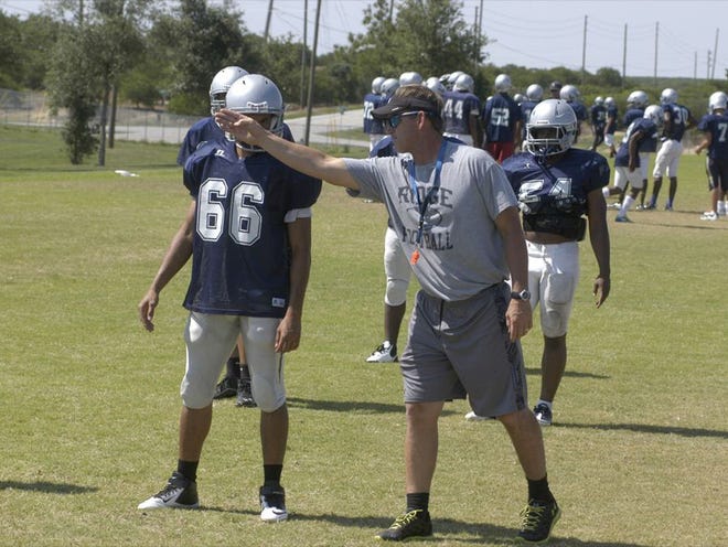 New Ridge coach Russ Rogers  works with Bolts defensive players during Monday's spring drills.