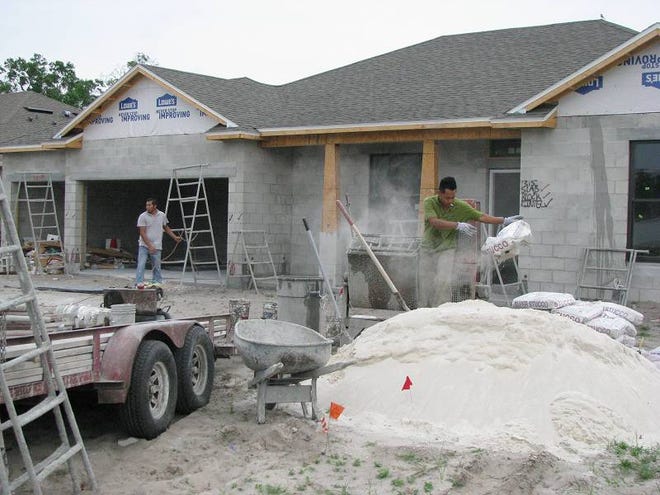 Crews for Gallery Homes of DeLand prepare to mix stucco to apply on a new home in the Glenwood Springs subdivision of DeLand.