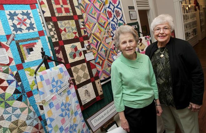 (John Clark/The Gazette) Eloise Buthe, left, and Geral Dean Page with some of the quilts on display as part of the Belmont Historical Society's quilt exhibit at their museum located at 40 Catawba St. in Belmont.