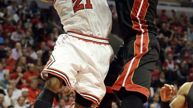 All ball! Miami center Chris Bosh blocks a shot by Bulls forward Jimmy Butler in the Heat’s runaway victory Monday night in Chicago. (AP Photo/Nam Y. Huh)