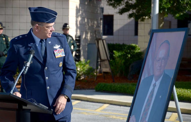 Major General Emmett Titshaw, Adjutant General of the Florida National Guard, looks a photograph of former St. Johns County Sheriff Neil Perry during a ceremony naming the St. Johns County Sheriff's Office's headquarter buildings as the Neil J. Perry Criminal Justice Complex on Tuesday, May 14, 2013. By PETER WILLOTT, peter.willott@staugustine.com