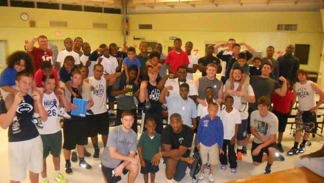 Members of the William T. Dwyer High School football team and the kids they mentor at nearby Grove Park Elementary as part of the Big Brothers Big Sisters “Think Big Club”.