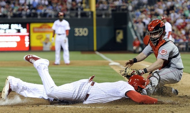 The Phillies' Ryan Howard beats a tag by the Reds' Ryan Hanigan and scores on a Carlos Ruiz sacrifice fly in the eighth inning Friday. The Phillies won 5-3.