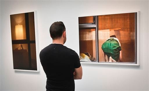 A visitor views the photography of Arne Svenson on Thursday, May 16, 2013 at the Julie Saul Gallery in New York. Residents of a New York luxury apartment building are upset over the exhibition by Svenson who secretly made their pictures from his window across the street.