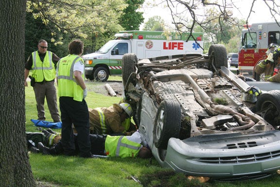 Emergency responders work to free a victim from a vehicle involved in a rollover accident Friday morning on M-21 and Stage Road in Ionia Township.