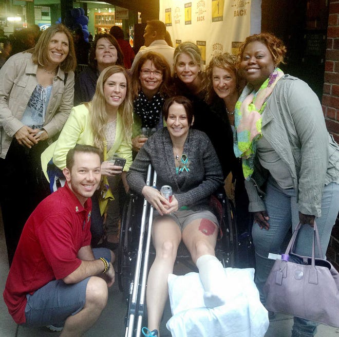 Nicholas Yanni, 32, and his wife, Lee-Ann, pose with a group of nurses from the Tufts Medical Center in Boston where they were treated after being injured in the Boston Marathon bombing. Contributed photo