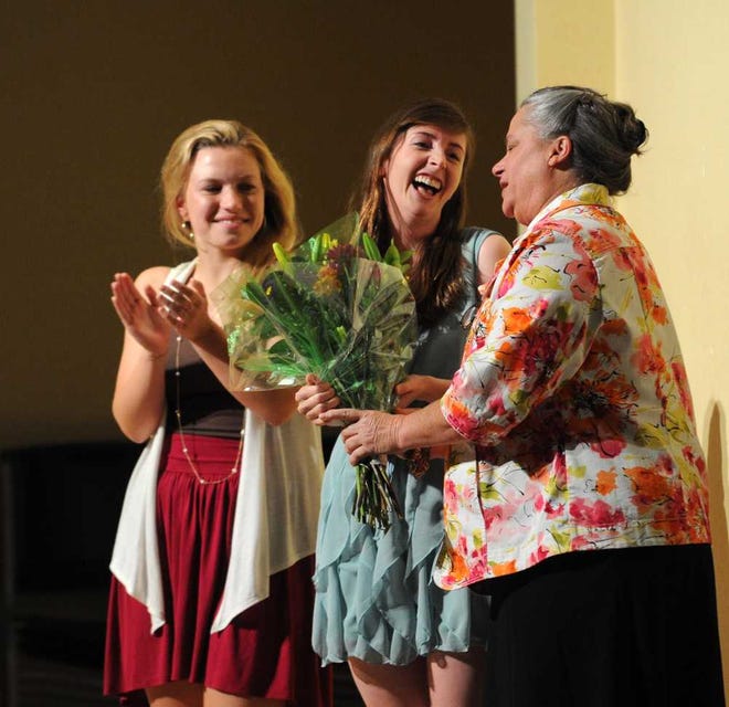 Hicks, retiring head of the upper school at Augusta Prep, receives flowers from seniors Megan Fechter (left) and Alexis Baker during a special program produced by the students. Hicks previously was Fort Gordon's commanding general.