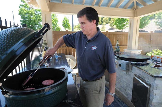 Mike Pond grills burgers on a Big Green Egg at Pete Alewine Pool & Spa on Washington Road in Evans. The CSRA Hog Toss Big Green Egg Cookoff N' Cornhole Tournament will be held June 1.