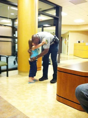 Officer Artie Swinton with the Gaston County Police Department spoke with 4-year-old Emma Duncan at CaroMont Regional Medical Center on May 4 and gave her a plastic badge. The personalized attention from the officer helped calm the girl’s fear of police.