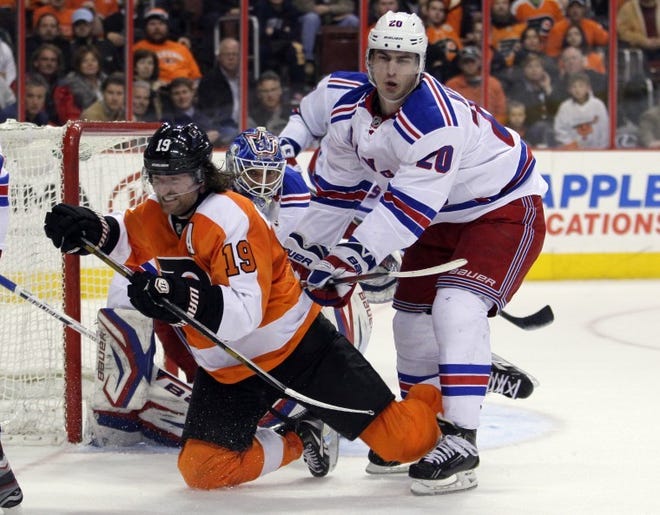 Rangers goalie Henrik Lundqvist watches as the Flyers' Scott Hartrnell (left) is pushed to the ice by the Rangers' Chris Kreider during a game on Tuesday, March 26 in Philadelphia.