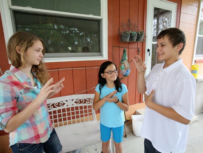 Cammie, from left, Ashley and Boyd use sign language to converse at thier Lakeland home