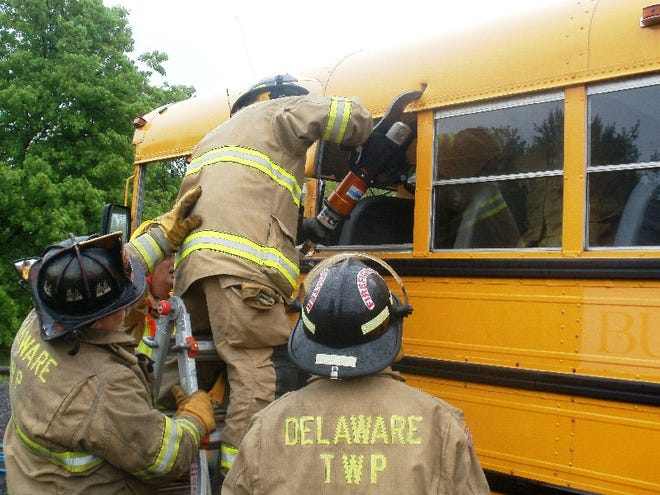 A Delaware Township Volunteer Fire Co. firefighter uses an extraction tool to cut into a school bus donated by the First Student Bus Co. for the exercise.