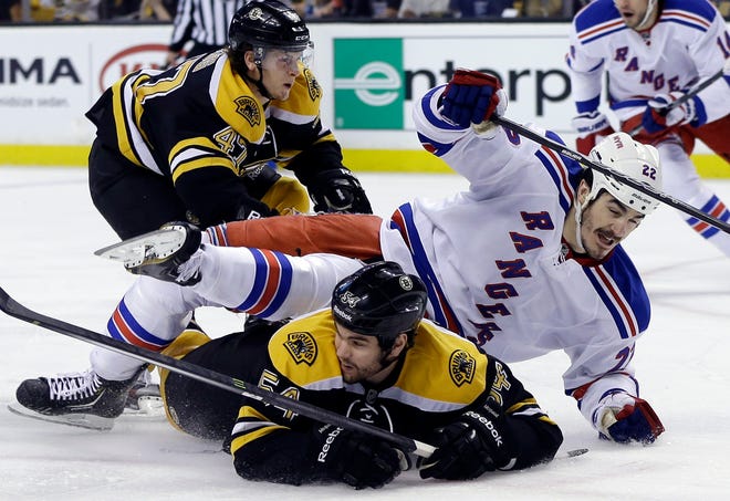 New York Rangers center Brian Boyle (22) goes down to the ice as he chases the puck against Boston Bruins defensemen Adam McQuaid (54) and Torey Krug (47) during the first period in Game 2 of the NHL Eastern Conference semifinal hockey playoff series in Boston, Sunday, May 19, 2013.