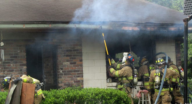 Ocala firefighters battle a house fire in the 2700 block of Southwest 17th Circle Tuesday morning.