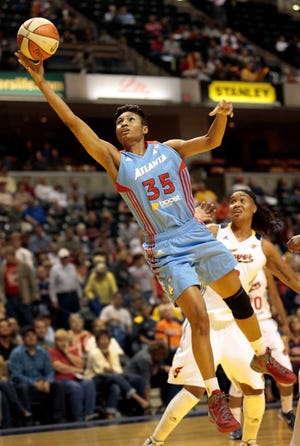 FILE - In this Oct. 2, 2012 file photo, Atlanta Dream guard Angel McCoughtry (35) goes to the basket in front of Indiana Fever forward Erlana Larkins during the first half of a WNBA basketball first-round playoff game in Indianapolis. After advancing to the 2010 and 2011 WNBA finals, the Atlanta Dream endured a tumultuous 2012 season, but star Angel McCoughtry and three other starters are returning for the 2013 season. (AP Photo/AJ Mast, File)