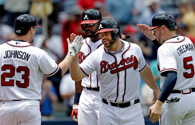 Atlanta's Evan Gattis (second from right) is greeted by teammates after hitting his first-career grand slam in the fourth inning.