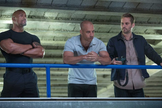 Dwayne Johnson (from left) offers Vin Diesel and Paul Walker a deal for their help in Fast & Furious 6.