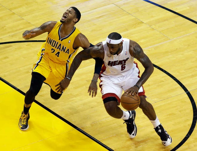 Miami's LeBron James drives against Indiana's Paul George. James scored 30 points, including a game-winning layup as time expired in the overtime period.