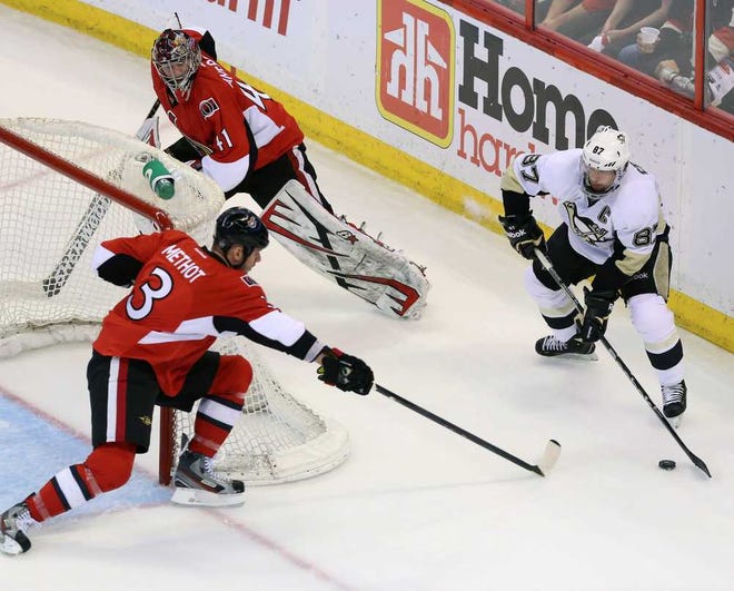 Pittsburgh's Sidney Crosby (right) looks to pass as Ottawa goalie Craig Andersonis caught behind the net and Marc Methot tries to knock the puck away Wednesday.