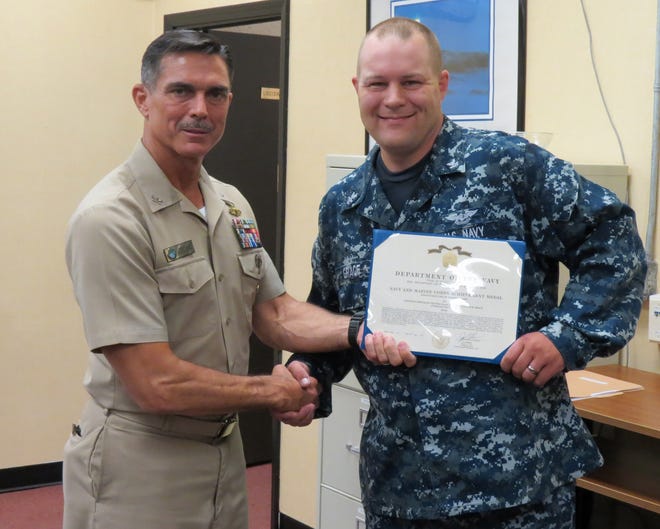 Rear Admiral David Gale presents a Navy Afloat Maintenance Training Strategy (NAMTS) certificate to Machinist Mate 2nd Class Francisco Carrillo. Petty Officer Carrillo is assigned to SERMC's valve shop division and received a Navy Enlisted Code in valve repair through the NAMTS program at SERMC.