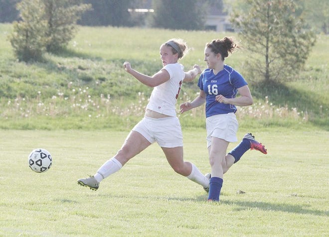 Portland senior Nicole Green kicks in the game-winning goal ahead of Ionia’s Madeline Wieber Tuesday night in the second half of the Raiders Capital Area Activities Conference Cup game against the Bulldogs.