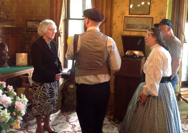 John Walker provides Irene Valentine (left) with history about her donated victrola. Dressed in period wear is Anne Johnson. COURTESY PHOTO