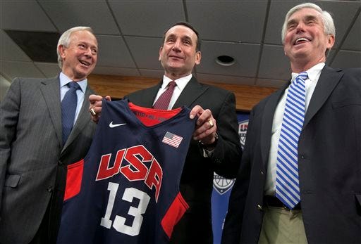 Duke University basketball coach Mike Krzyzewski, center, holds a Team USA jersey, as he is flanked by school President Richard Broadhead, left, and Director of Athletics Kevin White at a news conference in Durham on Thursday. Krzyzewski is back as the U.S. men's national team coach and ready for another run at Olympic gold.