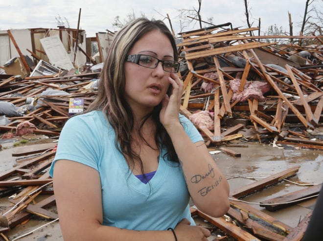LaTisha Garcia wipes a tear from her eye Thursday in front of her demolished home as she talks about carrying her injured daughter following Sunday's tornado in Moore, Okla.