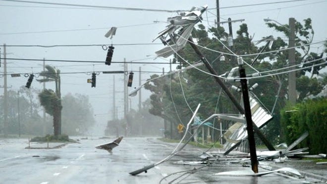 Aluminum and debris from the neighboring Royal Manor mobile home park flies through the air and wraps around the lines at Gateway Blvd. and Military Trail as broken power poles block Military Trail while Hurricane Wilma passed through Palm Beach County Monday, Oct. 24, 2005.