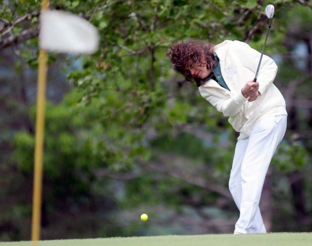 Mary Beth Simpson, who is legally blind, chips on to the green while playing in the Drive for the blind golf outing.