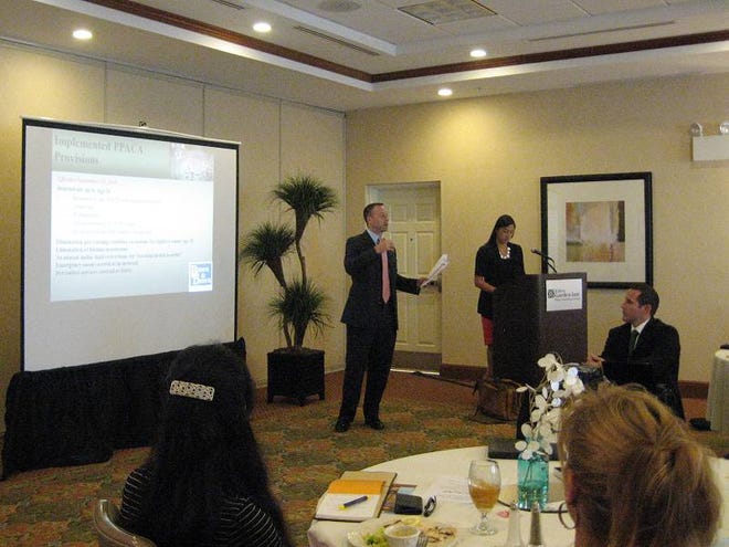 Chase Foy, left, and Kathleen Kam, employee benefit consultants with Brown & Brown, brief Flagler County small-business owners on the healthcare changes coming as a result of the Affordable Care Act.