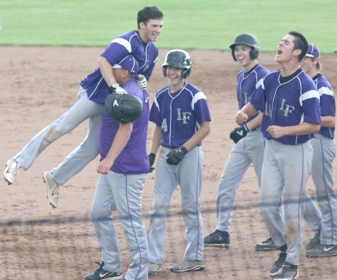 Little Falls coach Bryan Shepardson carries Nick Luppino off the field following Luppino's game-winning his against Herkimer Thursday.