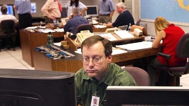 Specialist James Franklin keeps an eye on the weather tracking computers at The National Hurricane Center. Cydney Scott/2004 Post File Photo