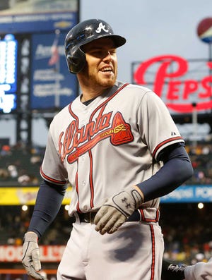 Atlanta Braves' Freddie Freeman (5) turns back with a smile as he heads to the dugout after hitting a two-run home run in the first inning of a baseball game against the New York Mets at Citi Field, Friday, May 24, 3013, in New York. (AP Photo/Paul J. Bereswill)