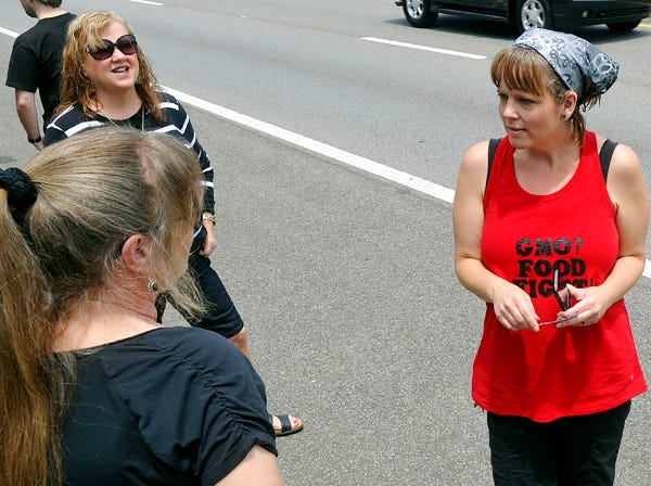 Gadsden protest organizer Deanna Guest, right, talks with supporters Saturday during the March Against Monsanto in Gadsden. The protest was part of a national event to raise awareness about genetically modified organisms used in foods and the Monsanto Company, which 
produces genetically modified seeds.