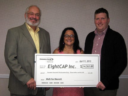 Yolanda Lewis, Consumers Energy public affairs manager, presents a check for the Consumers Energy match funding to John Van Nieuwenhuyzen, EightCAP, Inc. president, and Dan Petersen, vice president for Community Action Services. The total raised in EightCAP's 2013 Walk for Warmth campaign was $46,813.