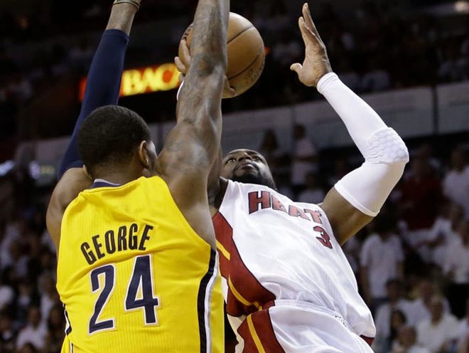 Miami guard Dwyane Wade shoots as Indiana's Paul George defends on Friday.
LYNNE SLADKY | THE ASSOCIATED PRESS