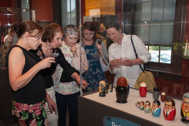Visitors look at a display of political figures from around the world in the "Matryoshka: The Russian Nesting Dolls" exhibit at the Museum of Russian Icons in Clinton.