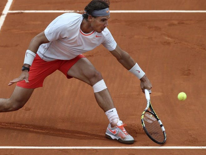 Spain's Rafael Nadal returns a shot  against Germany's Daniel Brands in their first-round match in the French Open tennis tournament on Monday. Nadal won in four sets.
(Michel Euler | THE ASSOCIATED PRESS)