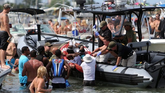 A man who was hit over the head with a bottle and was cut on his upper arm is helped onto a Palm Beach County Sheriff's boat after he was involved in a fight during Memorial Day weekend at Peanut Island in West Palm Beach, Fla., Sunday, May 26, 2013. The fight occured around 4:00 p.m. when the Sheriff's department responded shortly after the altercation started.