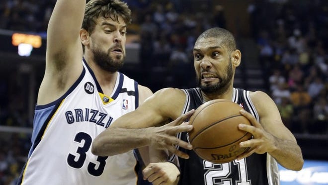 The San Antonio Spurs’ Tim Duncan drives to the basket as Memphis Grizzlies center Marc Gasol defends in the finale of the West series Monday night. The Spurs’ savvy, skill and size could derail the Heat’s title hopes. (AP Photo/Danny Johnston)