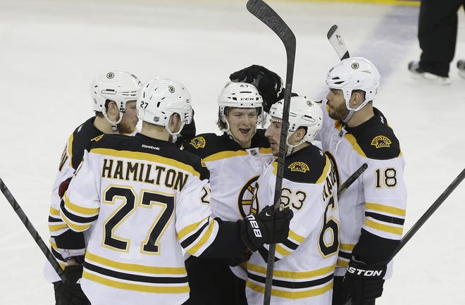 Boston Bruins' Torey Krug, center, celebrates with teammates Dougie Hamilton (27), Brad Marchand (63) and Nathan Horton (18) after scoring a goal during the second period in Game 4 of the Eastern Conference semifinals in the NHL hockey Stanley Cup playoffs against the New York Rangers, Thursday, May 23, 2013, in New York. (AP Photo/Frank Franklin II)