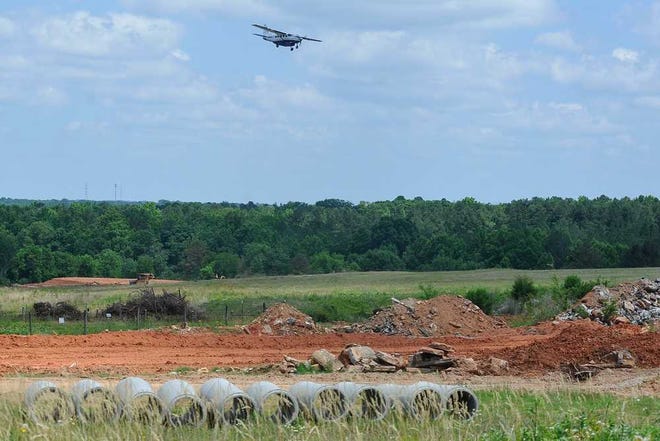 An airplane flies over the construction site for a runway extension at Athens-Ben Epps Airport in Athens, Ga., Wednesday, May 29, 2013. (AJ Reynolds/Staff)