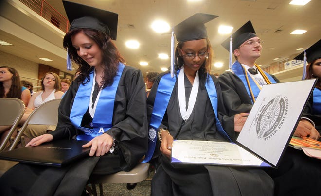Cleveland Early College High School graduates look at their diplomas after receiving them at the 2012 commencement ceremony. (Star file photo by Brittany Randolph)