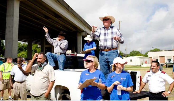 Auctioneer Gene Cockerham (left) and ringman Joey Phillips donate their time to work the crowd for bids at the Salvation Army Auto Auction.