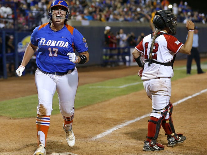 Florida's Lauren Haeger reacts as she scores past Nebraska's Taylor Edwards in the 15th inning during the Women's College World Series softball game Saturday in Oklahoma City.