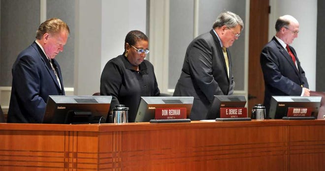 Bruce.Lipsky@jacksonville.com City Council members Don Redman (from left), Denise Lee, Robin Lumb and Matt Schellenberg bow their heads as the Rev. Robert Barton, Westside Baptist Church, delivers the invocation on May 28 in Jacksonville.