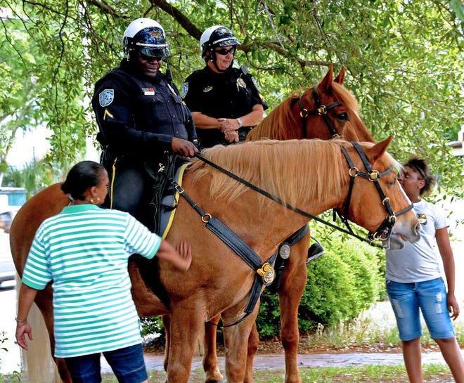 Corey Dickstein/Savannah Morning News   Neighbors visiting with Savannah-Chatham police during the department's Central Precinct Roll Call in the Streets Saturday at East 36th Street and Waters Avenue visit with mounted patrol officers.