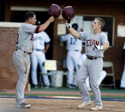 Elon's Wil Leathers, right, tips his helmet to teammate Antonio Alvarez after Leathers hit a two-run home run during Friday night's game.
